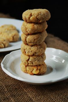 a stack of cookies sitting on top of a white plate next to two plates filled with cookies