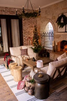 a living room filled with furniture and a fire place in front of a brick wall