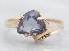 Sparkle and shine with this heart shaped synthetic alexandrite ring. Made with yellow gold and featuring a solitaire bypass design, it's the perfect accessory for any occasion. Show off your unique style with this stunning and playful piece!This stone dates back to the 1950s when synthetic corundum was produced to imitate synthetic alexandrite. In the vintage and estate industry, these synthetic corundum (synthetic sapphire) gemstones from this period are almost always referred to as synthetic a June Birthday, Ring Heart, Alexandrite Ring, Bypass Ring, Heart Shaped Rings, Watch Chain, Sapphire Gemstone, Gold Heart, Pearl Pendant