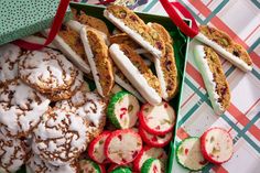 an assortment of pastries and desserts are displayed in a green tray on a table