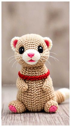 a crocheted cat sitting on top of a wooden table next to a wall