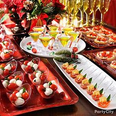 an assortment of appetizers on trays at a holiday party or celebration table