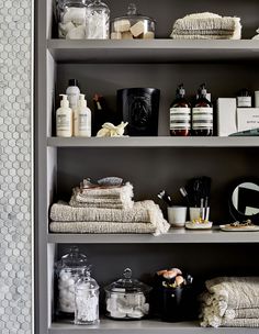 the shelves in this bathroom are filled with towels and personal care items, such as soaps