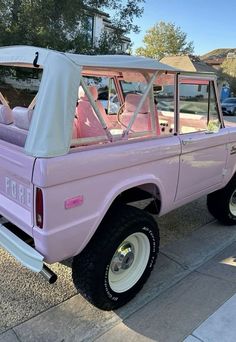 a pink pick up truck parked on the street