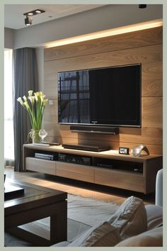 a living room with a large flat screen tv on top of a wooden entertainment center