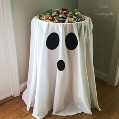 a white table with black polka dots on it and a ghost decoration in the corner