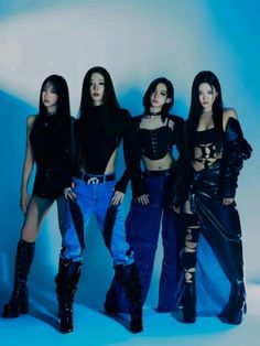 four women in black outfits posing for the camera with one woman wearing blue jeans and boots