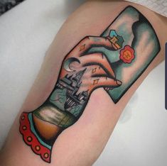 a woman's arm with a tattoo on it that has an image of a hand holding