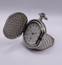 Here is a Brand New Quartz HC Pocket Watch, a great gift for father's day and for other special occasions for your beloved ones. POCKET WATCH or HUNTING CASE also becomes a DESK WATCH (see pics). - Brand - COLIBRI - Movement -  Quartz - Case: Shiny Stainless Still. Case has clean top and bottom covers also     inner cover for engravings (see pics) - Dial: White color with shiny steel numbers and black printed    markings all around. Date at 6 o'clock. - Hands: 3 hands-hour, minute and second - Case size: 2.47 inches long, 1.79 inches wide and 0.66 inches thick or     (16.76mm thick) - No chain included only Pocket Watch itself - Has new battery No factory box or original factory papers available.  *All images are of actual item and You will receive exactly the same item which shows in pict Luxury Quartz Movement Pocket Watch, Metal Pocket Watch With Round Dial, Metal Pocket Watch With Round Dial As Gift, Metal Pocket Watch With Round Dial For Gift, Metal Watch Accessories With Round Dial For Gift, Formal Metal Pocket Watch, Metal Pocket Watch With Metal Dial As Gift, Stainless Steel Pocket Watch With Round Dial For Gift, Metal Analog Watch Accessories As Gifts