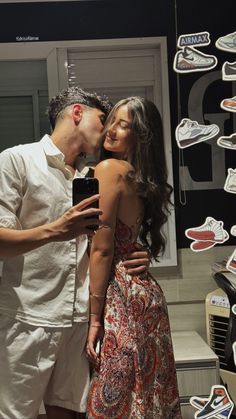 a man and woman standing next to each other in front of a display of shoes