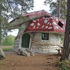 a small house made out of rocks in the middle of a forest with trees around it