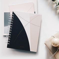 an open spiral notebook sitting on top of a table next to a christmas ornament