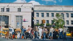 a group of people walking across a street