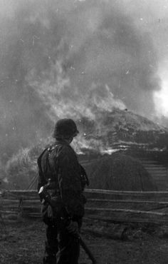 two soldiers standing in front of a fire