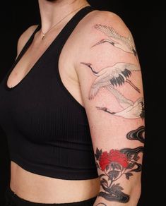 a woman with a tattoo on her arm and shoulder is standing in front of a black background