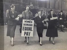 an old black and white photo shows women holding signs that read women demand equal pay