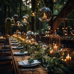 a long table is set with candles and greenery for an outdoor dinner in the woods