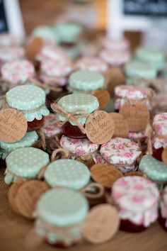 some little hearts that are on top of a wooden table with tags attached to them