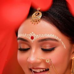 a woman with makeup and jewelry on her face