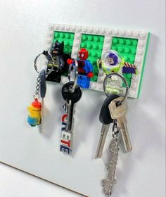 several lego key chains are hanging on a white board with keys attached to the pegs