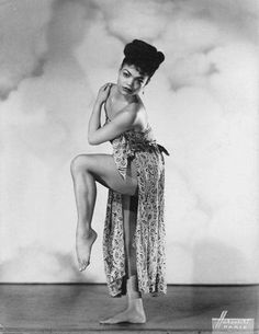 an old photo of a woman posing on the floor with her legs spread wide open