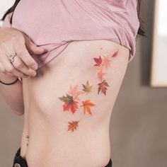 a woman's lower back with leaves on her body and the bottom part of her stomach