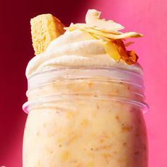 a glass jar filled with whipped cream and topped with a cracker on the top