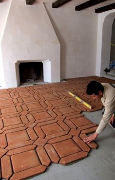 a man is laying bricks on the floor