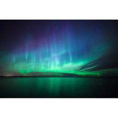 an aurora bore is seen in the sky above water with green and purple lights on it