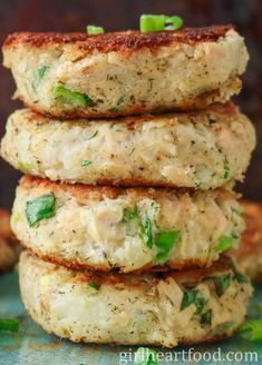 three crab cakes stacked on top of each other with green peppers and seasoning in the middle