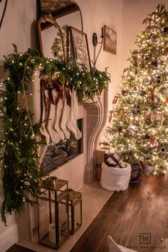 a living room with a christmas tree and stockings hanging on the fireplace mantels