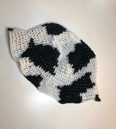 a black and white knitted hat sitting on top of a table