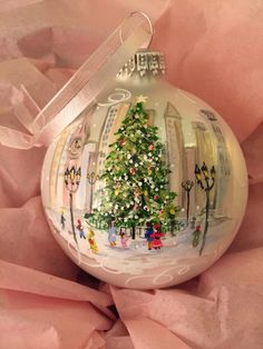 a glass ornament with a christmas tree on it