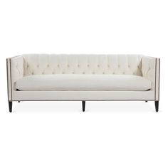 a white couch with black legs and buttons