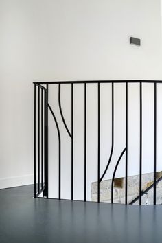 an empty room with white walls and black railings