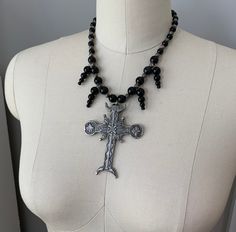 This beautiful, one-of-a-kind pewter ornate cross necklace will inspire all your moonlit nights. Handmade with black agate and glass beads. Measures 18 inches long and has a 2 inch extender chain. product details silver tone metals; Cross is soft pewter. 18 inches long with 2 inch extender black agate and glass beads VISIT MY SHOPS HERE * http://www.etsy.com/shop/HappyCatHouse * http://www.Etsy.com/shop/AnEnchantingCreature CONNECT * http://www.facebook.com/EnchantingCreature * https://www.insta Gothic Metal Cross Necklaces, Gothic Ankh Necklace In Metal, Gothic Ankh Metal Necklace, Halloween Silver Jewelry With Cross Pendant, Silver Ankh Gothic Necklace, Silver Cross Pendant Jewelry For Halloween, Ankh Shaped Black Metal Necklace, Black Ankh Necklace In Metal, Gothic Metal Cross Pendant Jewelry