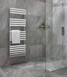 a bathroom with grey marble walls and tile flooring, along with a towel rack on the wall