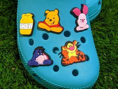 a pair of blue crocs with winnie the pooh stickers on them