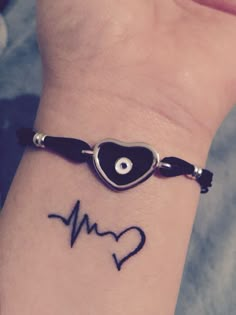 a wrist tattoo with a heart and an eye on it