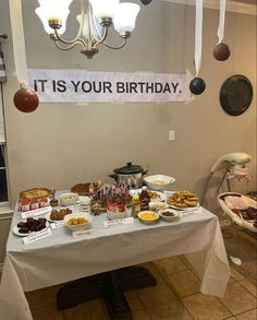 a table topped with lots of food next to a sign that says it is your birthday