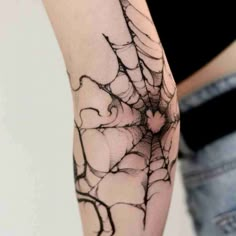 a spider web tattoo on the arm