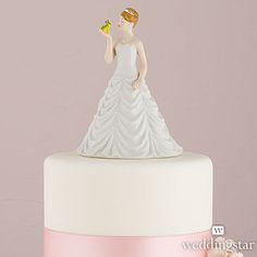 a wedding cake with a bride figurine holding a flower in her right hand