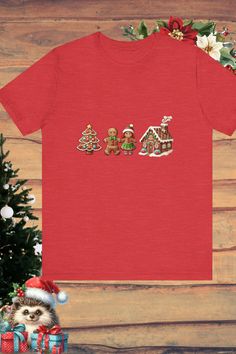 a red t - shirt with the word merry written on it next to a christmas tree