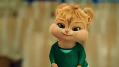 a close up of a cat figurine wearing a green shirt and holding something in its hand