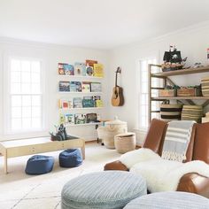 a living room filled with lots of furniture and bookshelves on the wall next to a window