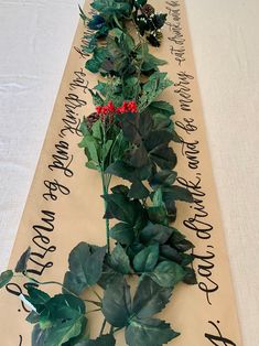 there is a long table runner with flowers on it and writing all over the place