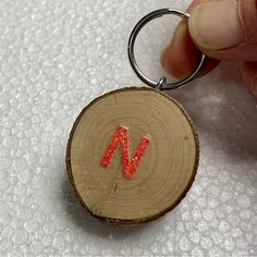 a piece of wood with the letter n painted on it is being held by a hand