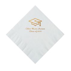 a white napkin with a gold graduation cap on it