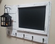 an old window frame is hung on the wall with hooks and a candle in it