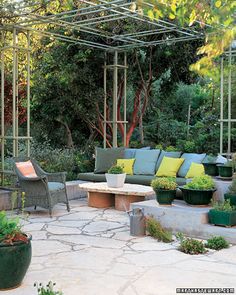 an outdoor living area with seating and potted plants